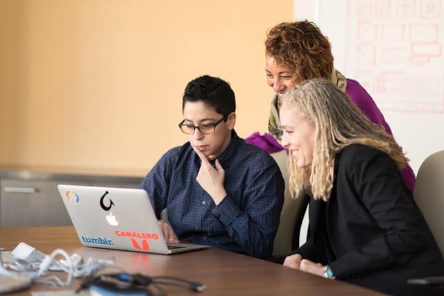 people working together in front of laptop screen