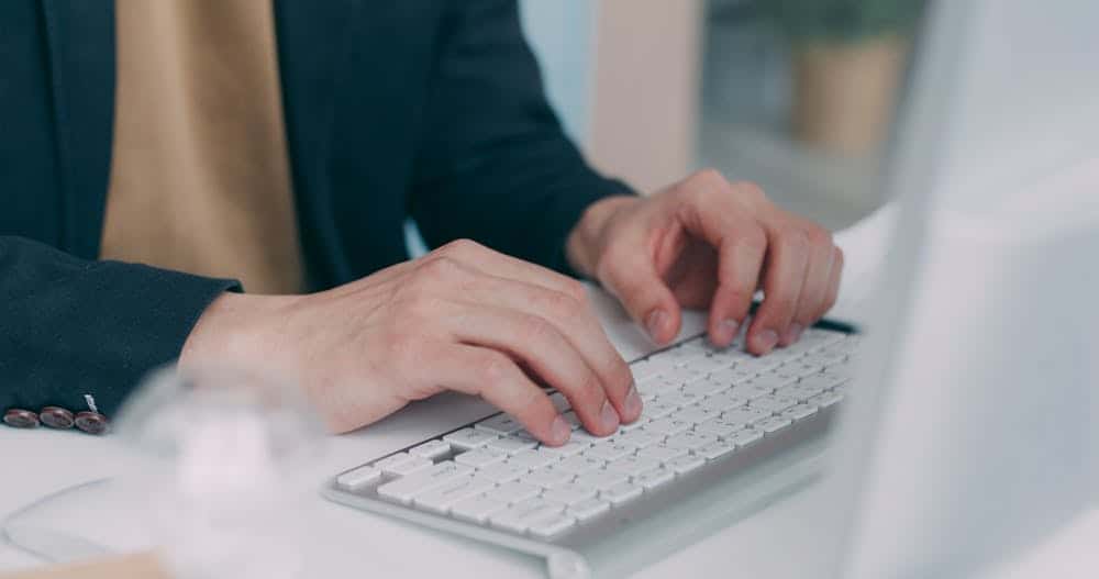 professional hands typing on white keyboard